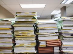 Stack of organized paperwork and files in an office setting